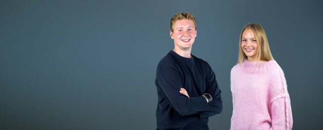 Gutt og jente ser i kamera og smiler.