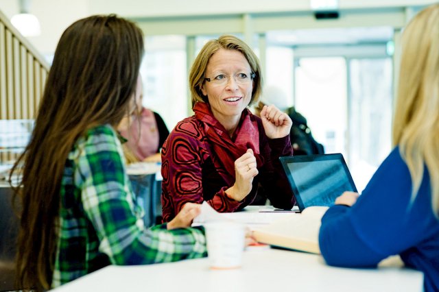 Tre studenter i en gruppe diskuterer