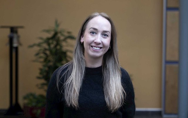 Smilende dame med langt blodt hår ser i kamera