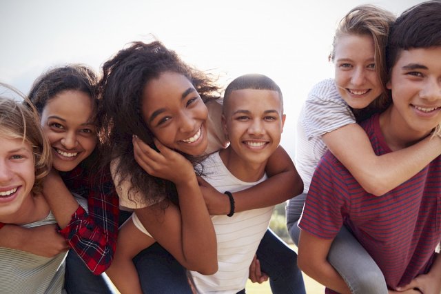 Ungdommer som holder rundt hverandre og smiler