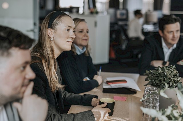 Voksne studenter sitter rundt et bord